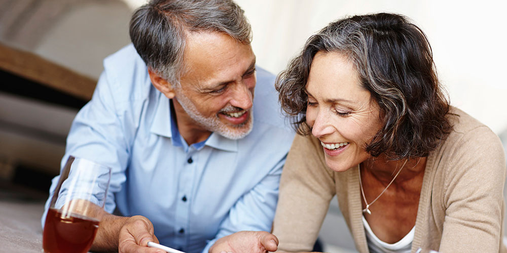 Man and women smiling and discussing document